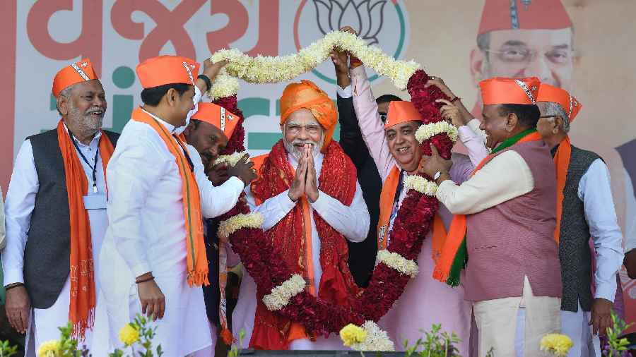 Prime Minister Narendra Modi being garlanded during a public meeting ahead of the Gujarat Assembly elections, in Palanpur