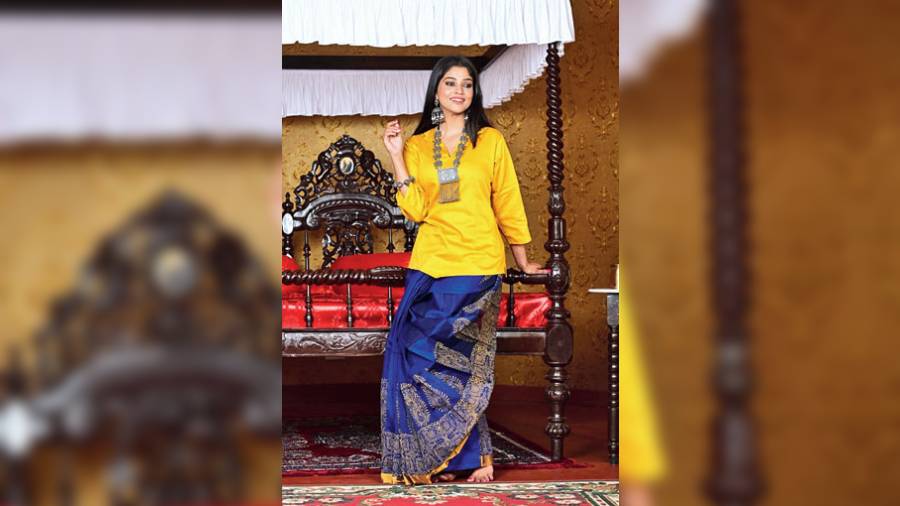Made in vibrant shades of blue and yellow, this kachcha-style dhoti skirt is made with resham and cotton thread used in an alternative pattern and block-printed with colour. Apt for an Indo-western style during the winter wedding season, the dhoti is paired with a cotton top.