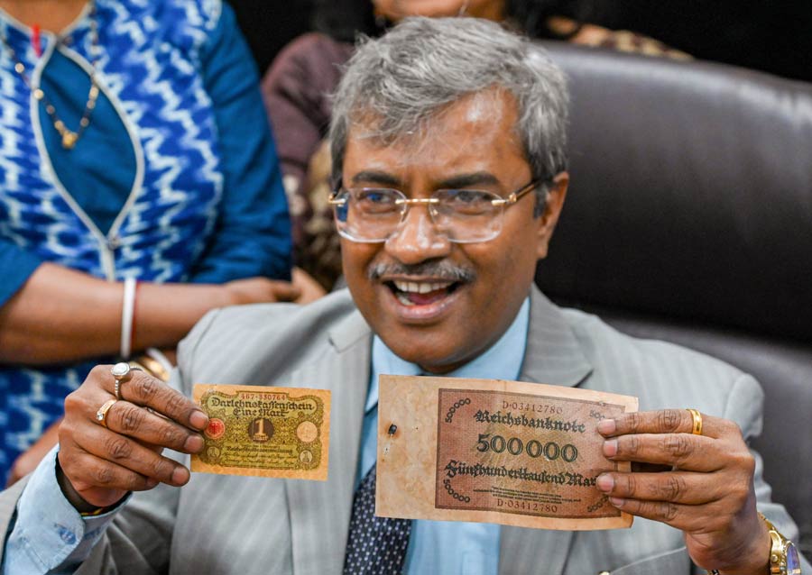 Administrator general and official trustee of West Bengal, Biplab Roy, displays German currencies during a press conference in Kolkata on Friday, November 25, 2022
