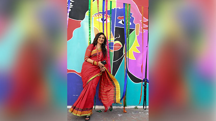 Rituparna Sengupta poses for the camera in front of the mural