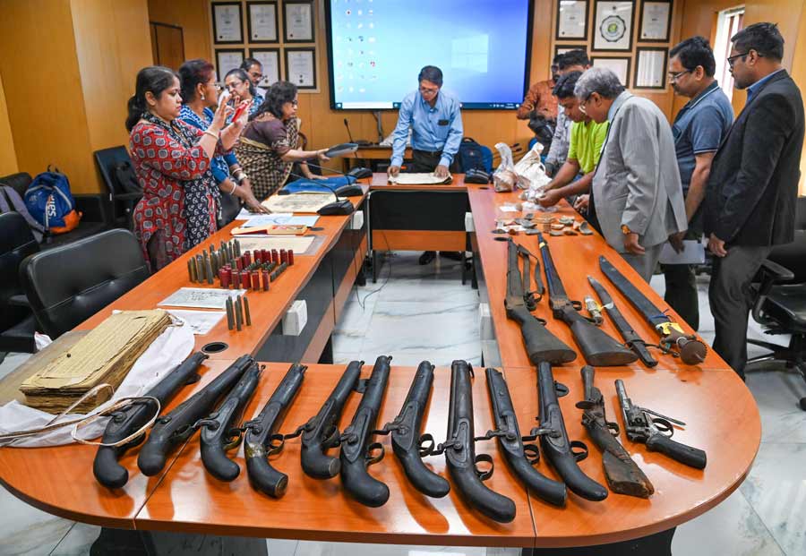 Administrator general and official trustee of West Bengal, Biplab Roy, and other officials display guns and antique cartridges with other valued articles during a press conference in Kolkata on Friday, November 25