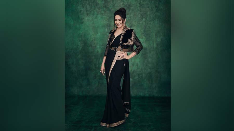 Black, bold, layers and belt: The gorgeous black sari-set on Madhuri Dixit Nene is stunning, and so is her embroidered jacket and the belt. If you are really feeling experimental and want to take it a notch higher, go for leather boots in the same colour of the belt. Try dark smokey eyes, keep the lips nude and opt for a quirky hair pin to complete the look.