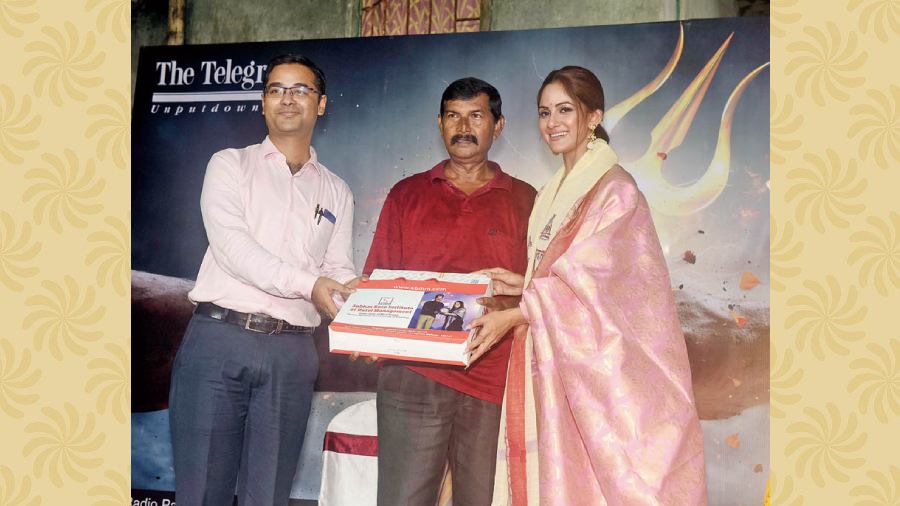 Sayan Chakraborty from SBIHM and Trina hand over a token of appreciation to the club’s secretary, Doot Kumar Mondal.