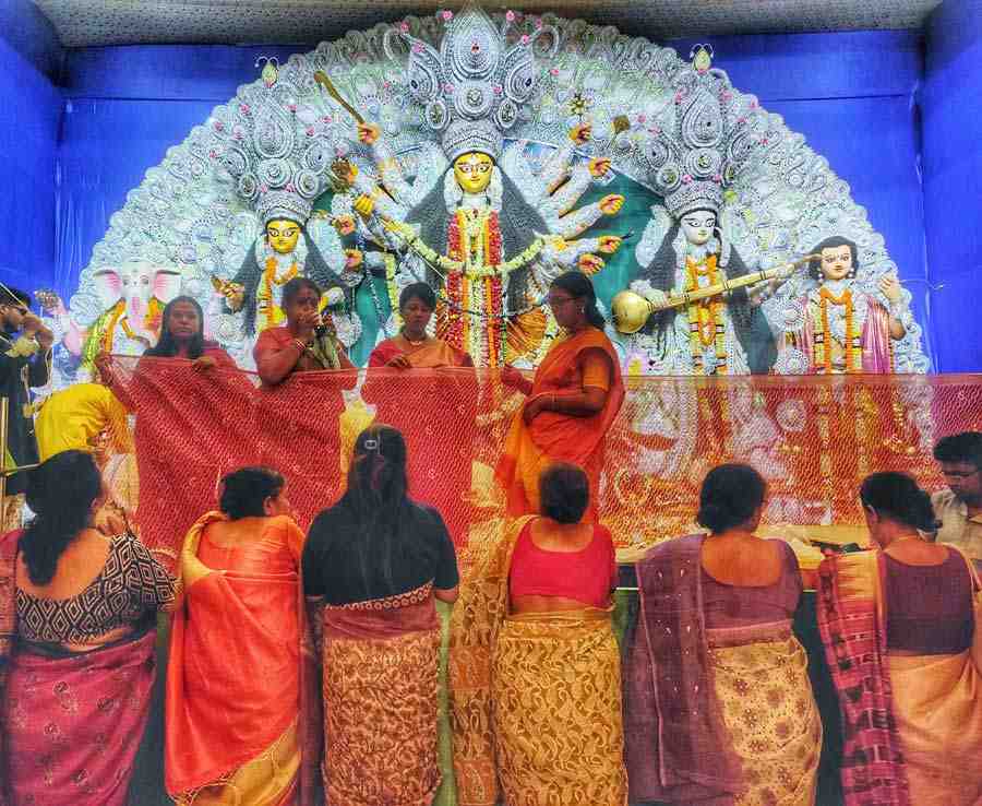 Devotees cover the food offerings made to Ma Durga on Ashtami, Monday, at Sports Council Sarbojanin, Baguiati. Rituals dictate that the food be covered to allow the goddess some privacy to make it into prasad