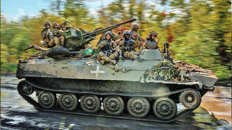 Ukrainian soldiers drive on an armoured vehicle as they cross the village of Shandrygolovo, near Lyman, Ukraine, on Tuesday. 