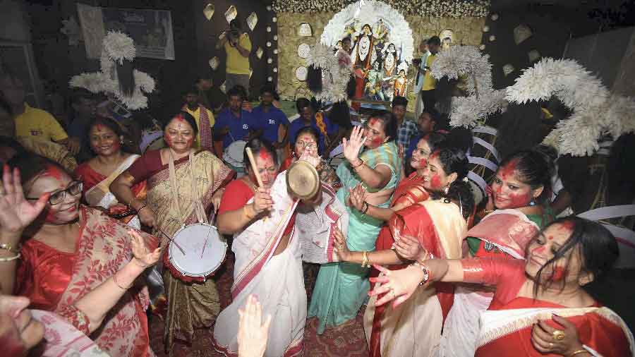 Women participate in Sindoor Khela during Vijayadashami celebrations at a community puja pandal in Patna