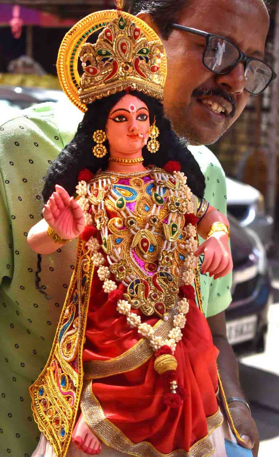 A man carries an idol of goddess Lakshmi