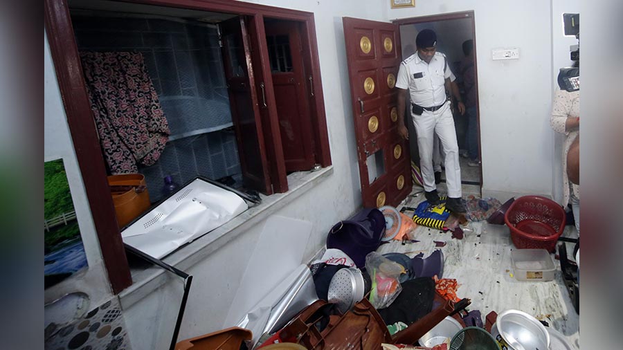 A police official checks out the vandalised house in Haridevpur