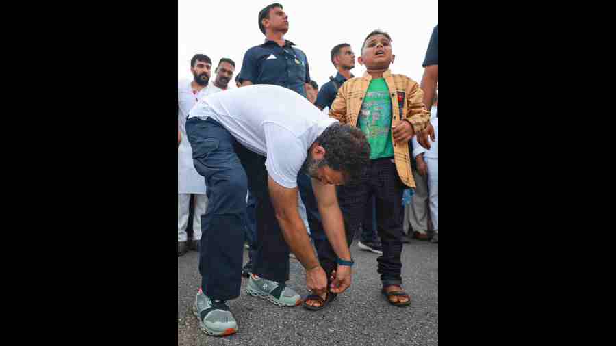 Rahul Gandhi helps a boy in wearing his footwears