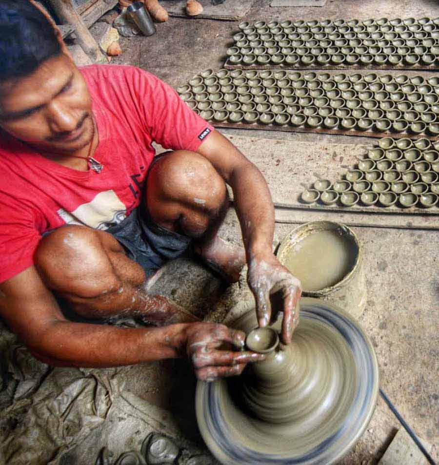 A potter makes clay lamps at Dakshindari in Ultadanga