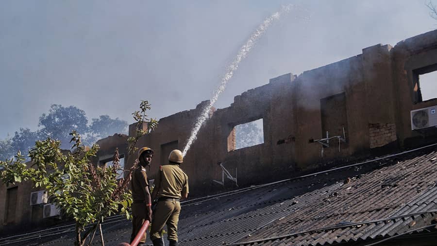Firemen spray water to douse the flames at the studio godown in Tollygunge on Thursday morning