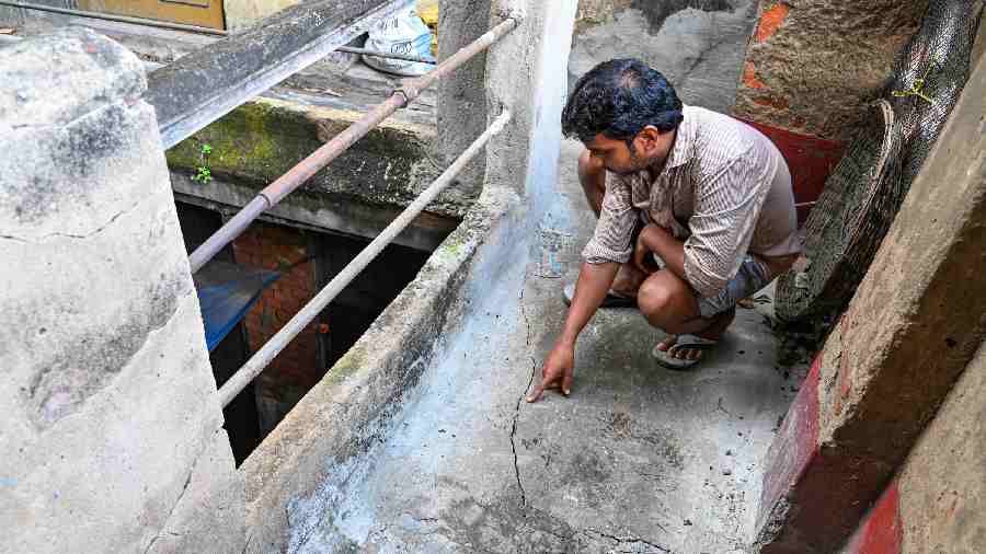 A resident shows the crack appeared at his house owing to some water seepage during work in the East-West Metro tunnel, at Bowbazar area in Calcutta