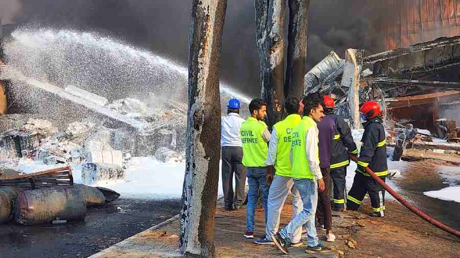 Firefighters try to douse a fire that broke out at an auto parts manufacturing company