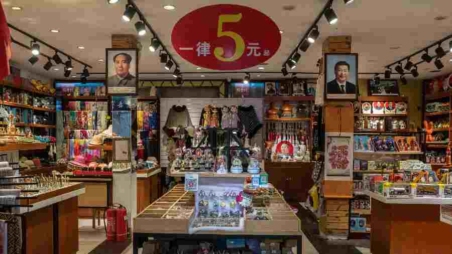Portraits of China’s famed leader Mao Zedong, left, and and current President Xi Jinping hang in a souvenir shop for tourists near Tiananmen Square in Beijing, October 11, 2022. 