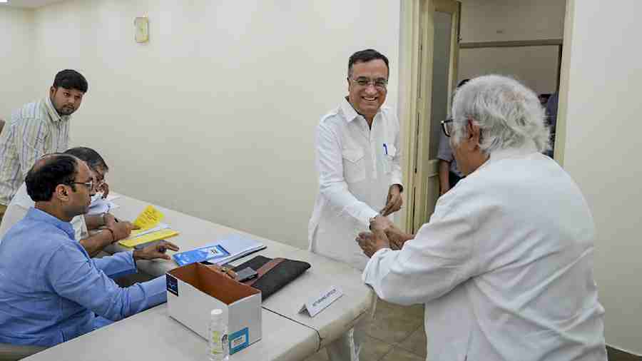 Ajay Maken and Jairam Ramesh shake hands during voting for the party's Presidential election at AICC headquarters, in New Delhi. 