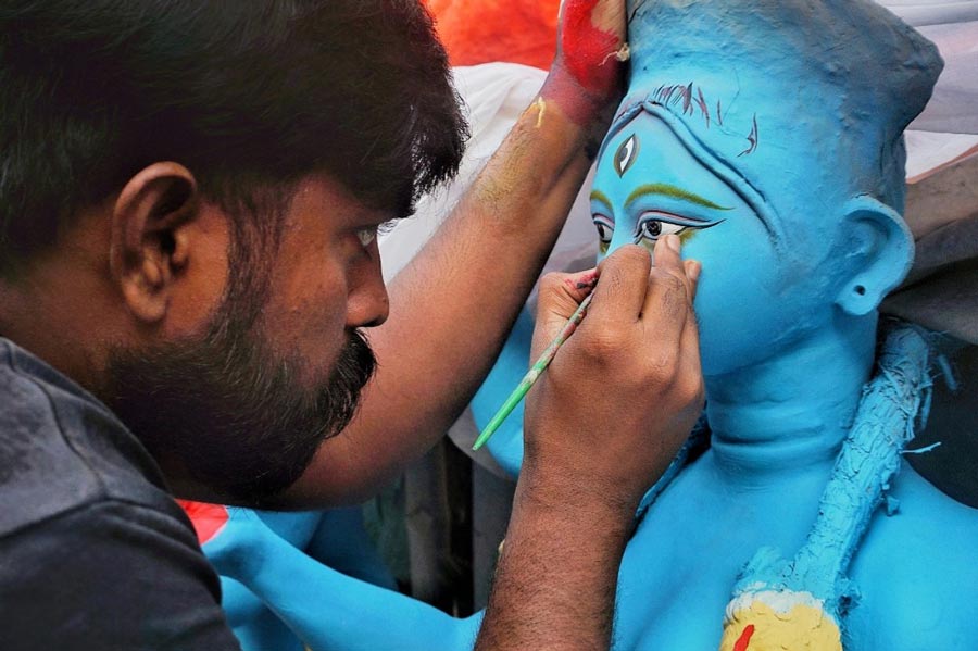 An artist paints the eyes of a Kali idol at Patuapara on Wednesday