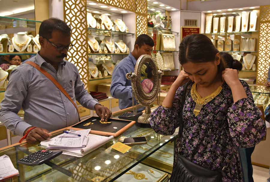 On the occasion of Dhanteras, a woman tries out a necklace at a jewellery showroom in Bowbazar on Saturday