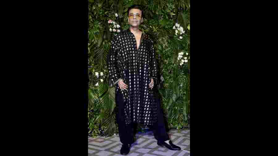 Film producer and director Karan Johar looks dapper in a black sherwani suit at the party hosted by Kriti Sanon. 