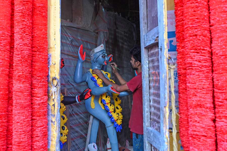 An artisan puts the finishing touches to an idol of goddess Kali at Kumartuli on Sunday