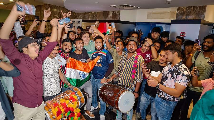 People celebrate after India won the ICC Men's T20 World Cup cricket match against Pakistan, during the live screening of the match at Satyam INOX, Patel Nagar in New Delhi, on October 23. 