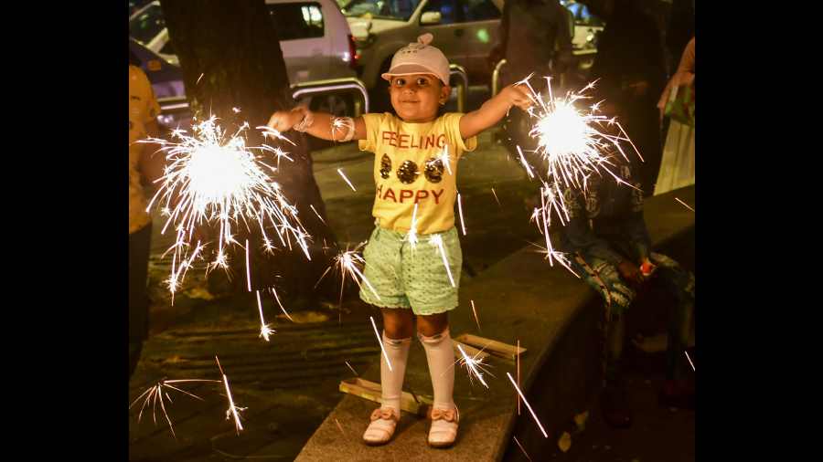 A child lights sparklers to celebrate the festival, in Mumbai