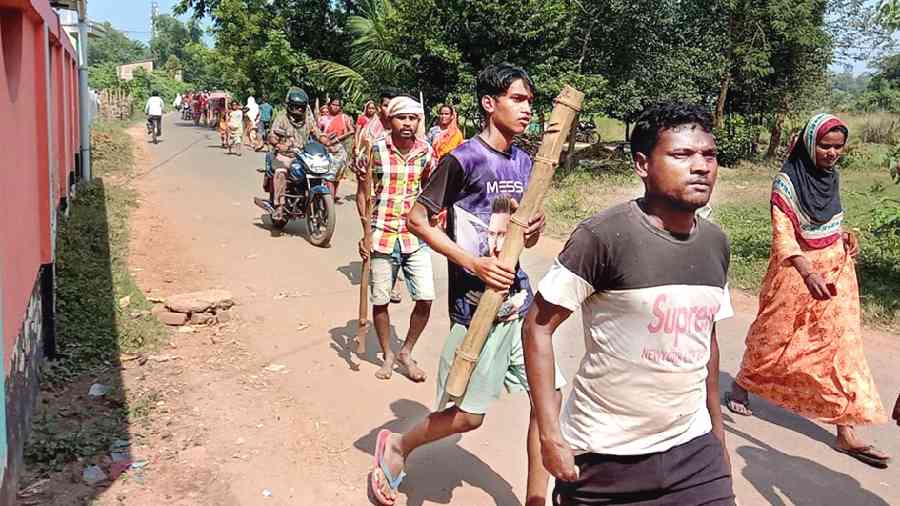 Villagers armed with sticks head for the pond on Wednesday