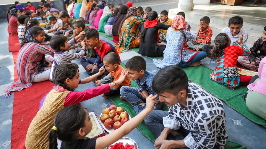 Girls put 'tika' on foreheads of boys at an orphanage in Jammu