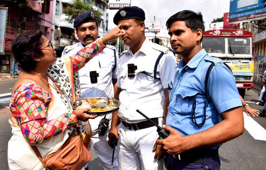 Policemen on duty in north Kolkata get a feel of Bhai Phonta on Thursday.