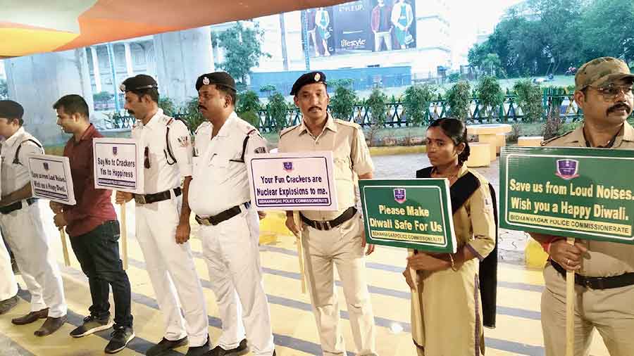 Police officers hold placards to spread awareness against noisy firecrackers