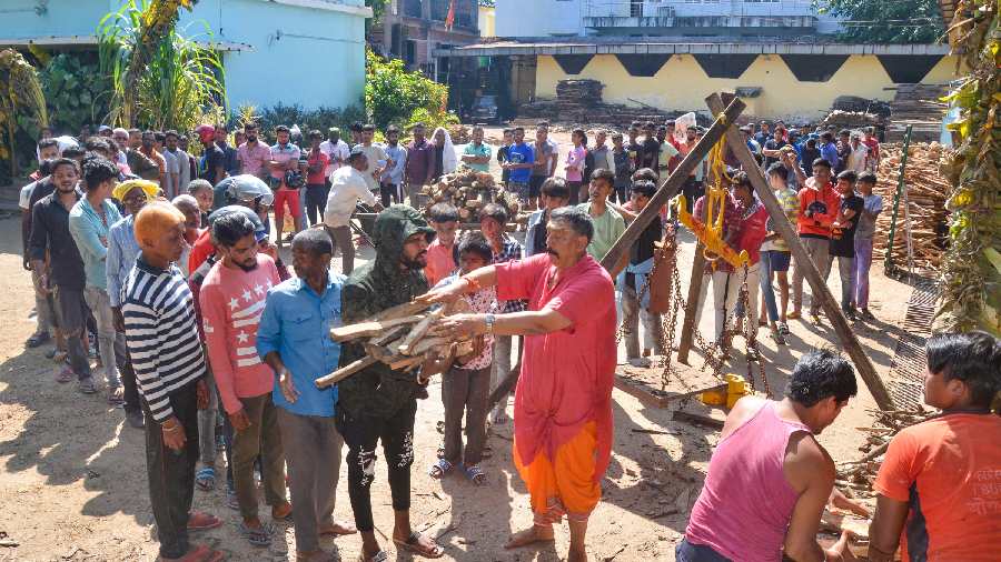 Volunteers distribute dry wood among locals during the second day of Chhath Puja festival in Ranchi