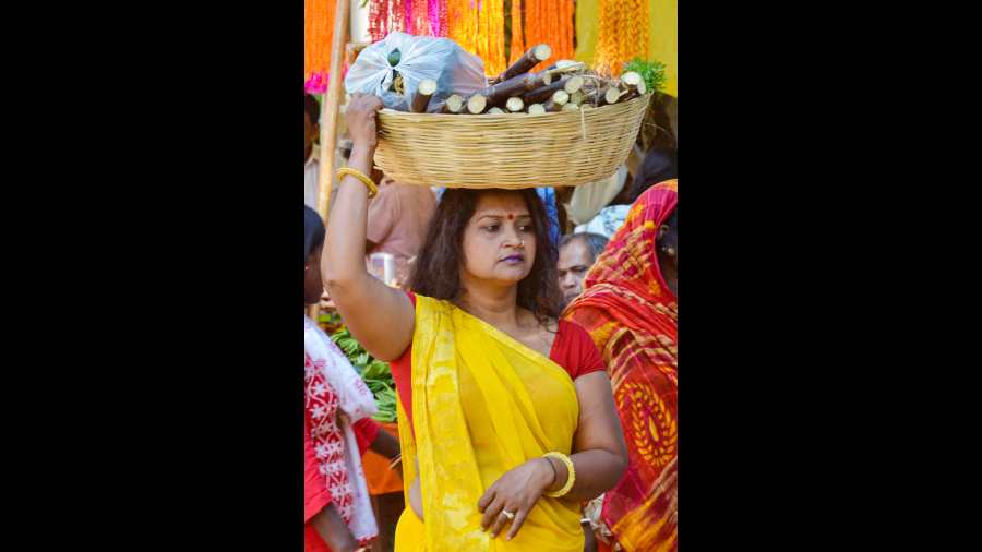 A devotee carries puja materials during the second day of Chhath Puja festival in Ranchi