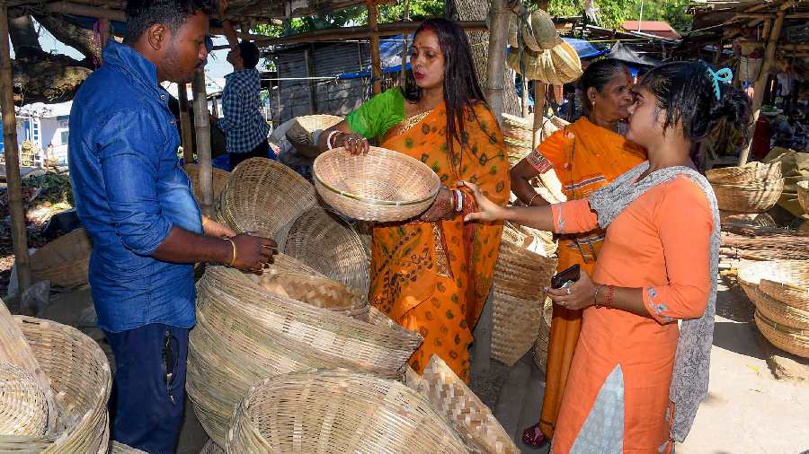 Women buy bamboo baskets to be used as puja materials during the second day of 'Chhath Puja' festival in Guwahati