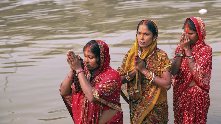 Women offer prayers on the first day of 'Chhath Puja' celebrations in Noida, Friday