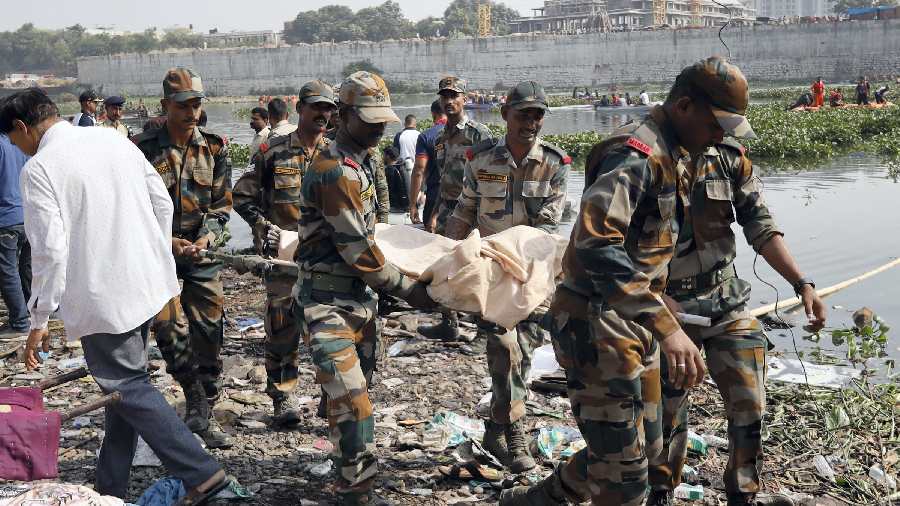 Armed Forces personnel carry the dead body of a victim as death count rises as the day proceeds