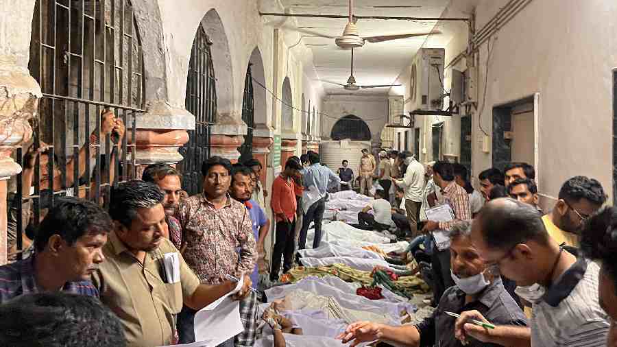 Family members and relatives near the dead bodies of victims who were killed at Civil Hospital