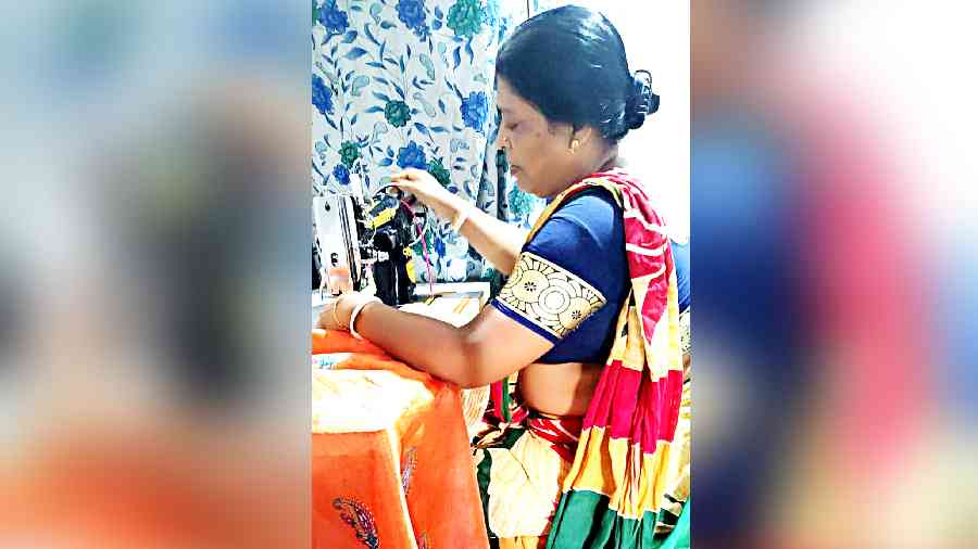 A woman works on a sewing machine she received