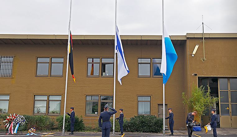 Flags are flown at half-mast in front of the old tower during a memorial service commemorating the 40th anniversary of the terrorist attack
