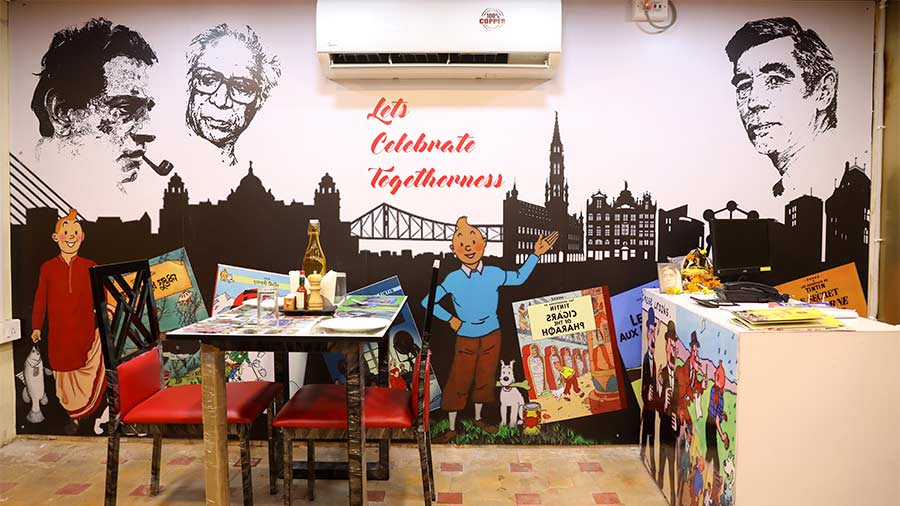 The blending of the Bengal and Brussels skylines alongside portraits of Satyajit Ray, Nirendranath Chakravarty and Herge