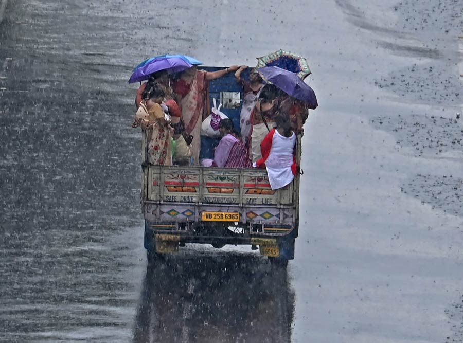 A group of women brave the rain on Chittaranjan Avenue to join the Durga Puja rally organised by the state government on Thursday.
