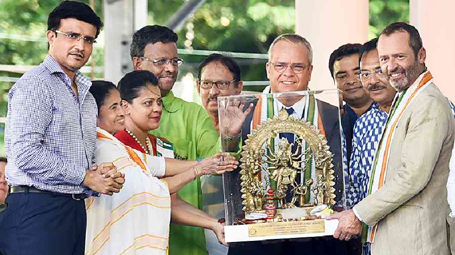 Tim Curtis (centre) and Eric Falt (extreme right) of Unesco receive a dokra statuette of Goddess Durga from chief minister Mamata Banerjee as former cricketer Sourav Ganguly and government representatives look on at the programme on Red Road on Thursday. 
