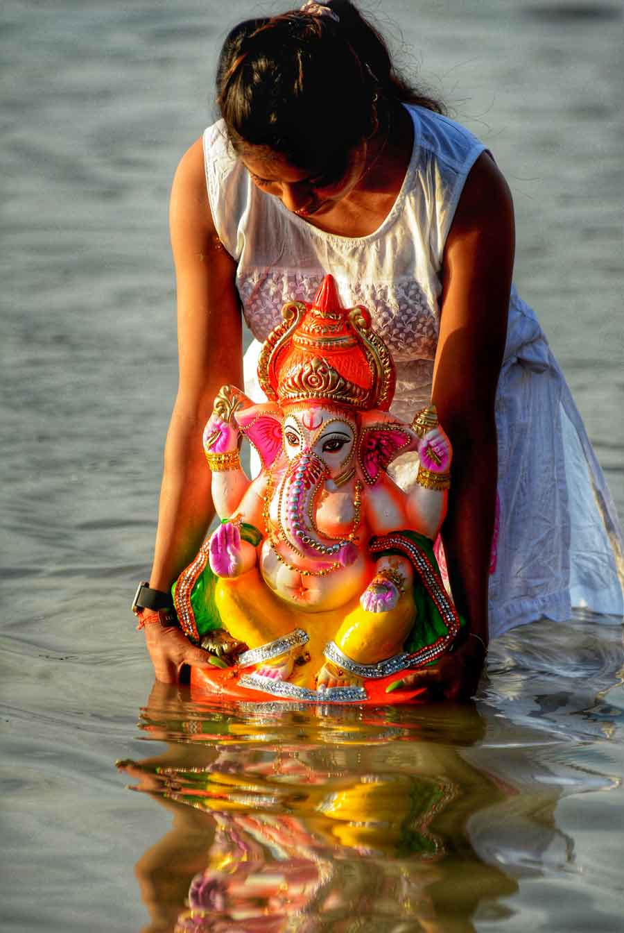 A girl immerses a Ganesh idol at Babughat on Friday.