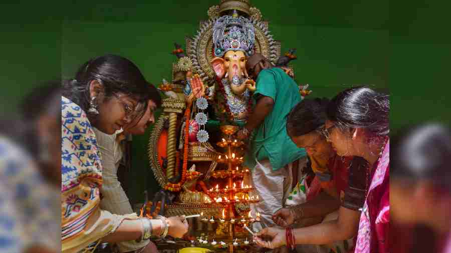 Devotees perform rituals before clay idols of Lord Ganesha at a community puja pandal, on the occasion of Ganesh Chaturthi in Calcutta.