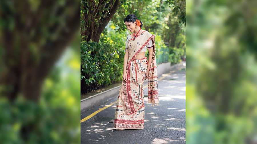 A glam traditional look in a mekhla chador sari made of tussore and eri silk, designed in red and black with a hint of silver. Perfect for trying a variety of stylish drapes for a statement festive look.