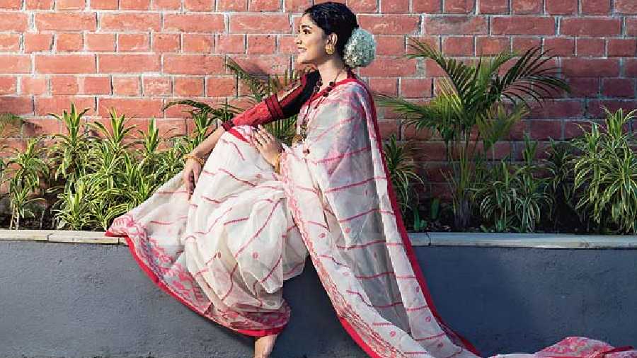 The classic and festive quintessential red-and-white muslin jamdani dhakai sari is designed with geometric dhakai print. A festive look loved by women of all generations.