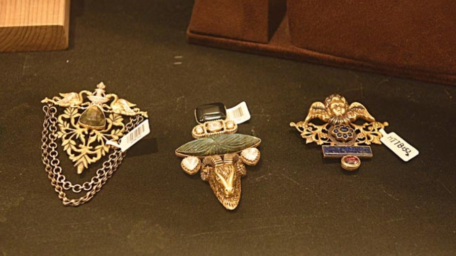 These stunning pieces of sterling silver brooches are layered with gold and studded with precious stones.