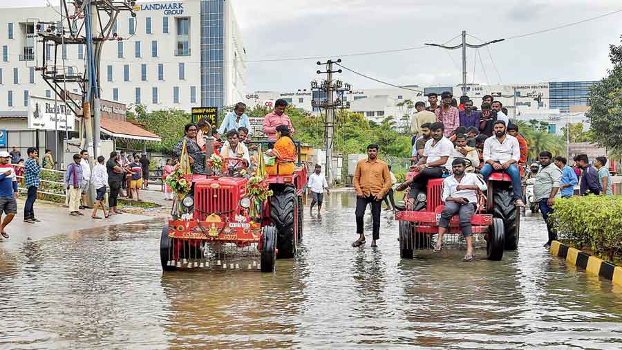 Stranded residents being evacuated by a tractor from waterlogged Yemalur  in Bangalore on Tuesday. 
