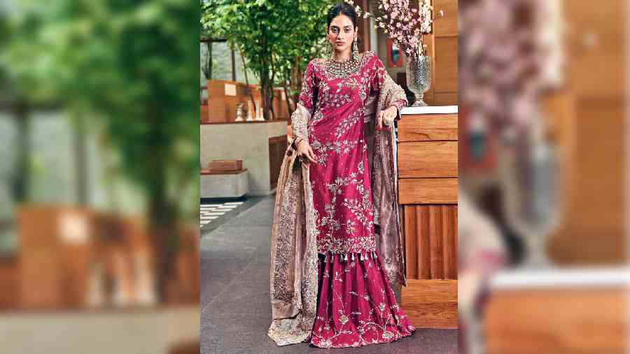 This dusty magenta gharara with a heavily embroidered tissue chaadar takes us back to the Mughal times where pure gold hand-work was popular among the royalty. The gharara has hidden pleats that almost make it look like a skirt when standing. A big part of this new collection is the use of tissue fabric that has a beautiful shine and dual tone to it. The entire outfit, including the chaadar, is laced in pure zardosi work, with jaal all over the outfit and a thick embellished border for the chaadar. The polki chaandbalis and necklace and the textured ponytail further elevate the look. This can easily be a fun Mehndi look.