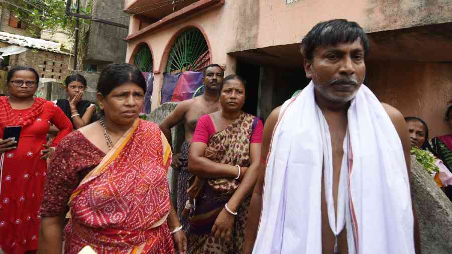 Atanu Dey’s father Biswanath (in white) and relatives outside their home in Baguiati’s Jagatpur on Wednesday. 