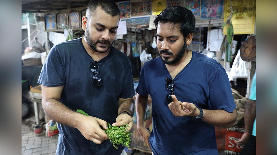 Auroni and (right) Zac examine a stalk of fiddlehead fern or ‘dheki shaak’