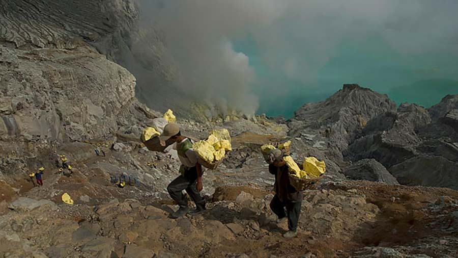 Miners lugging chunks of sulphur, a common sight in the areas surrounding the acid lake